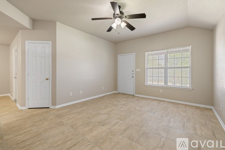 A spacious room with a ceiling fan and a window with blinds.