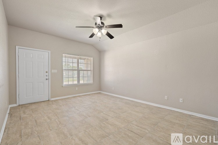 A room with a ceiling fan and a door.