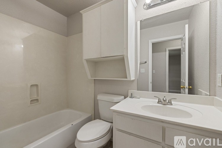 A white bathroom with a toilet, sink, and bathtub.