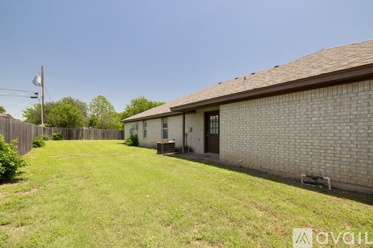 A house with a brown roof and a green lawn in front.