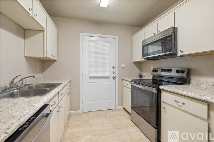 A kitchen with a sink, stove, and oven.