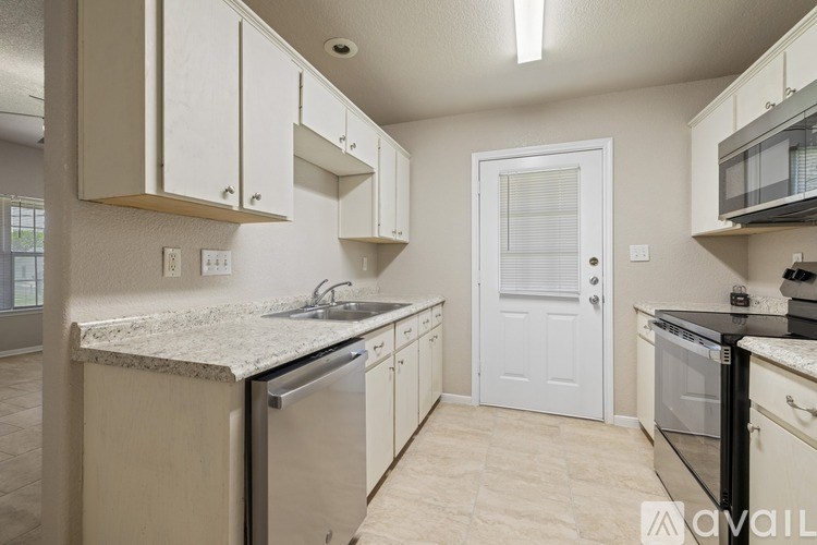A kitchen with white cabinets and a granite countertop.