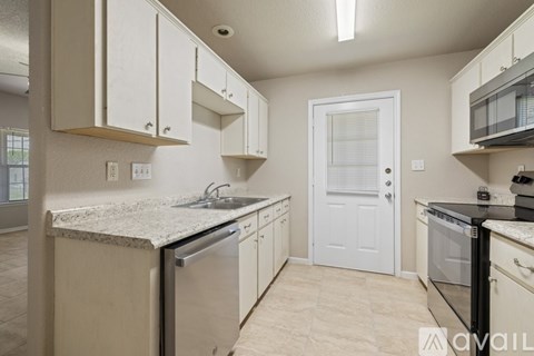 A kitchen with white cabinets and a granite countertop.