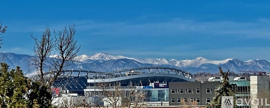 A stadium with a large arched roof is surrounded by mountains.