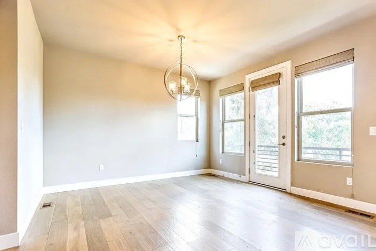A room with a wooden floor and a chandelier hanging from the ceiling.