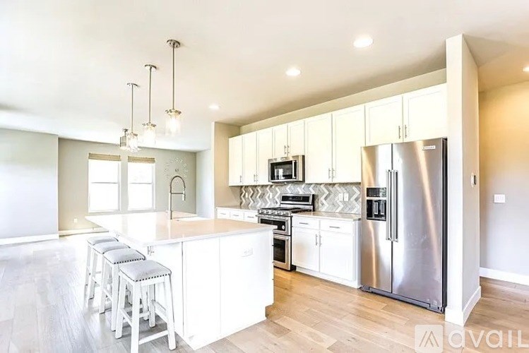 A modern kitchen with white cabinets and stainless steel appliances.