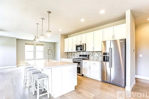 A modern kitchen with white cabinets and stainless steel appliances.