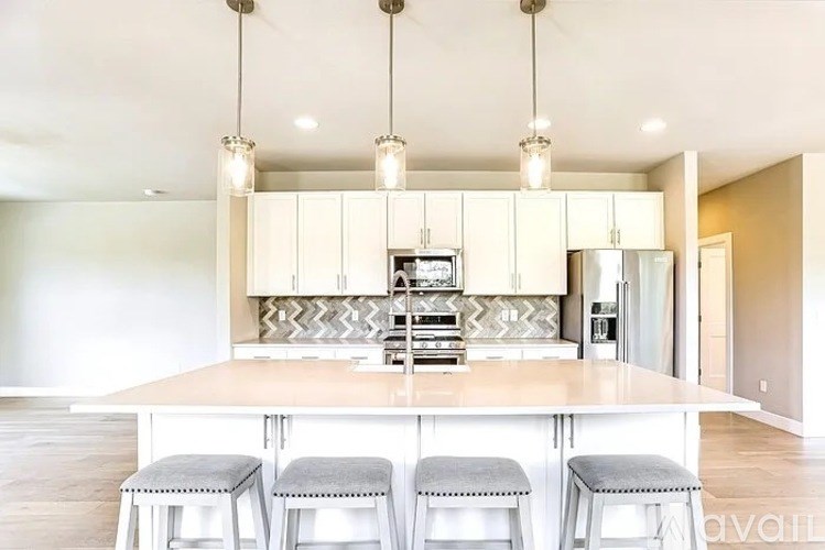 A kitchen with a center island and bar stools.