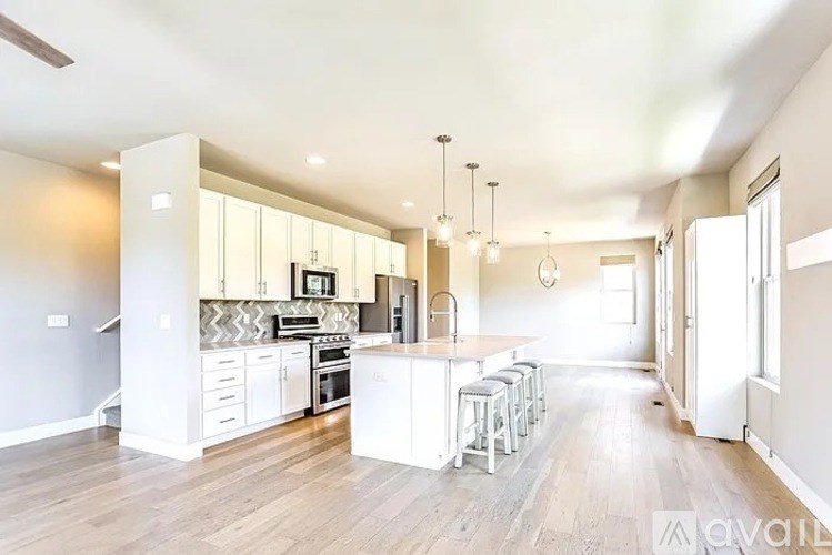 A modern kitchen with white cabinets and a central island.