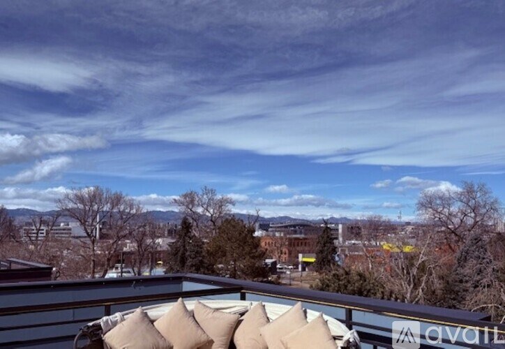 A balcony with a view of a cityscape and trees.