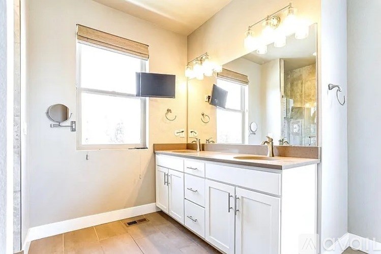 A bathroom with a sink, mirror, and cabinets.