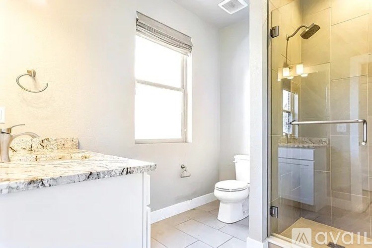 A bathroom with a marble countertop and a walk-in shower.