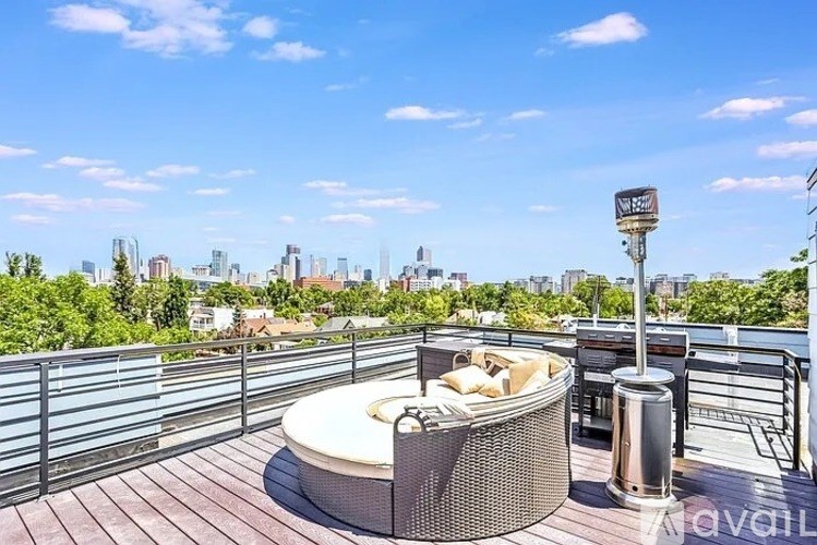 A hot tub sits on a wooden deck overlooking a city skyline.