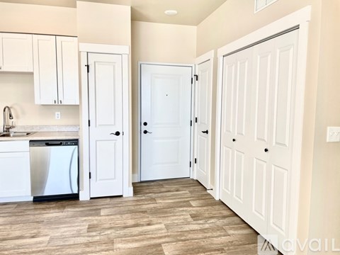 A kitchen with white cabinets and a white dishwasher.