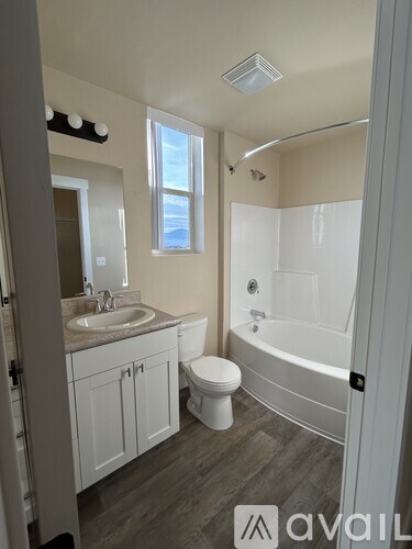 A bathroom with a toilet, sink, and bathtub.