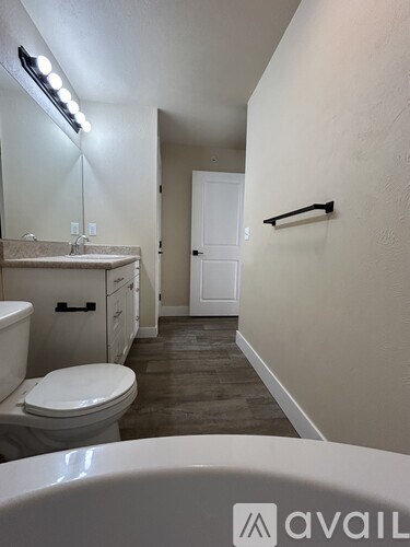 A bathroom with a toilet, sink, and a mirror.