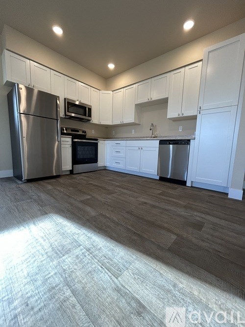 A kitchen with white cabinets and stainless steel appliances.
