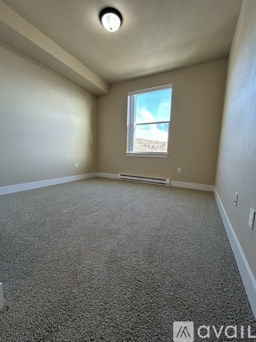 A room with a carpeted floor and a window.