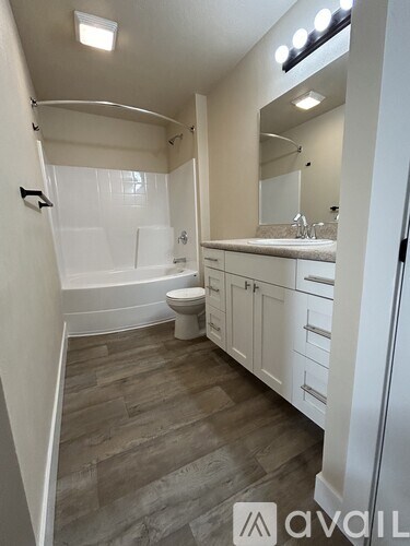 A bathroom with a toilet, sink, and mirror.