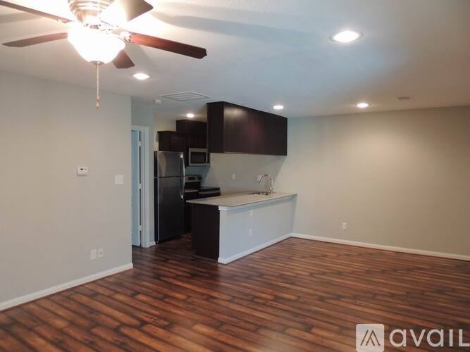 A room with a ceiling fan and wooden flooring.