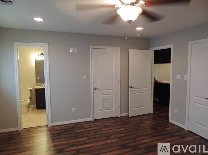 A room with a ceiling fan and wooden floors.