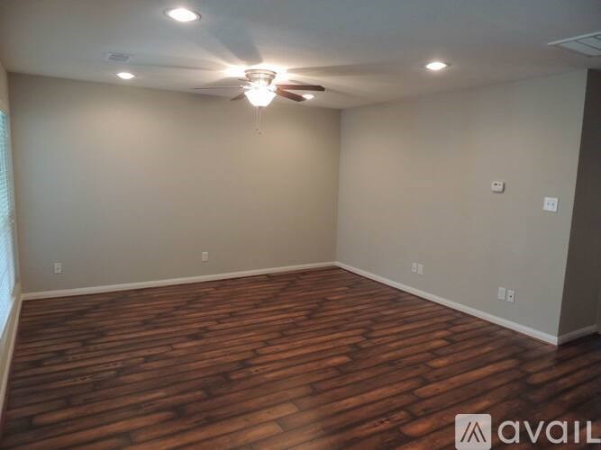 A room with wooden flooring and a ceiling fan.