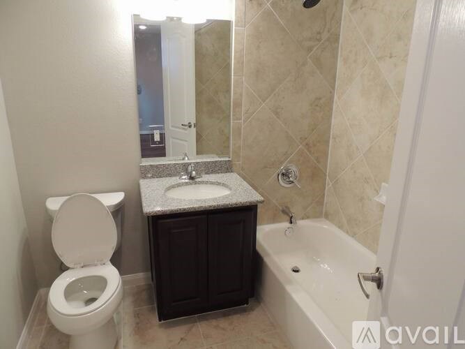 A bathroom with a toilet, sink, and bathtub.
