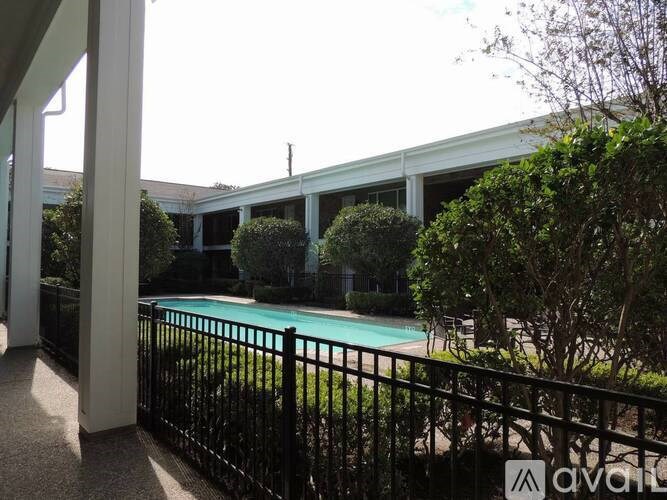 A black fence surrounds a green pool.