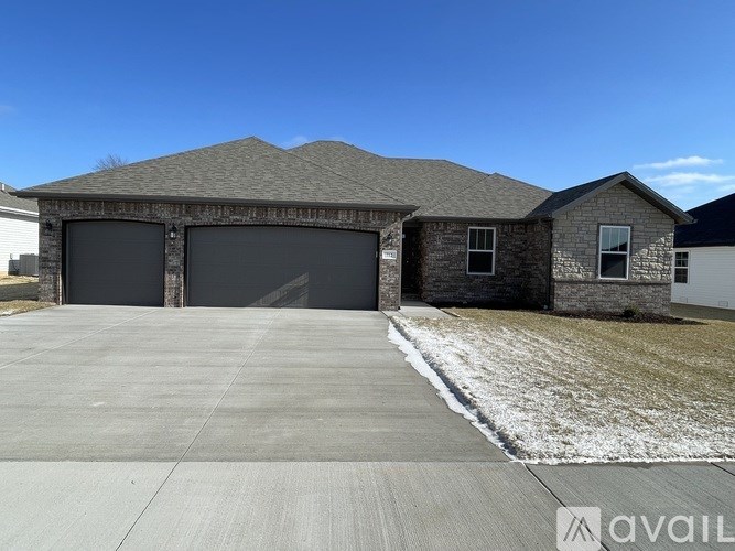 A house with a grey roof and a garage door that is closed.