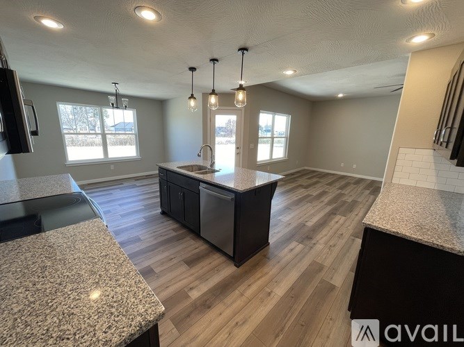 A kitchen with granite countertops and wooden floors.