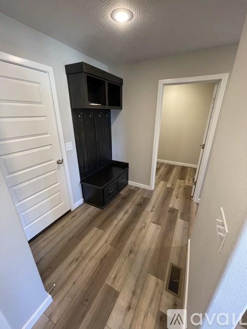 A room with a wooden floor and a black cabinet.