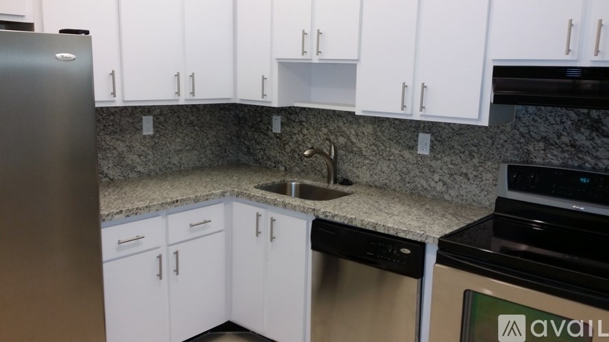A kitchen with white cabinets and a granite countertop.