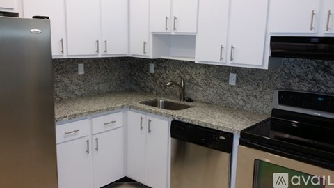 A kitchen with white cabinets and a granite countertop.
