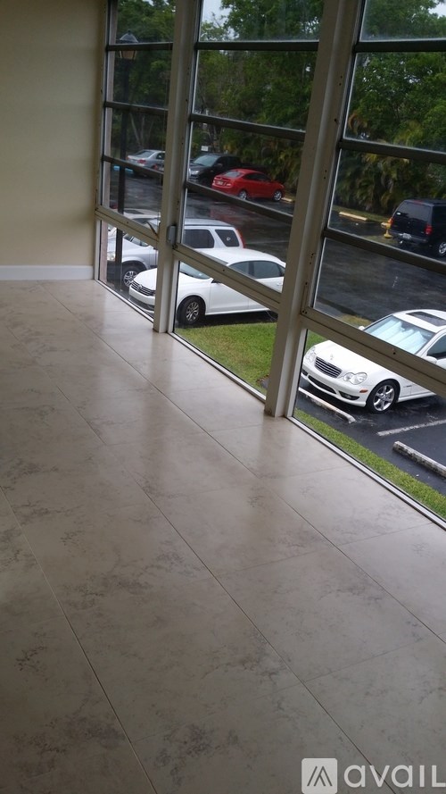 A car is parked outside a building with a glass window.