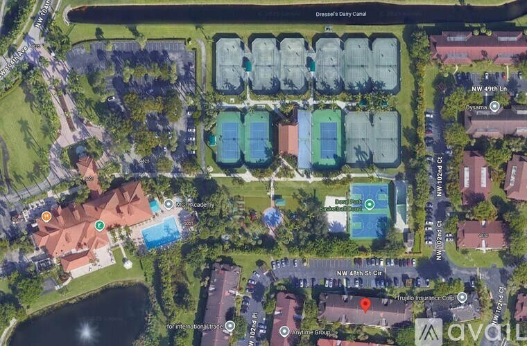 A bird's eye view of a neighborhood with a swimming pool and a tennis court.