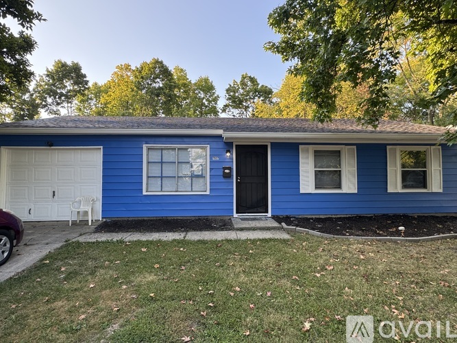 A blue house with a black door and white trim.