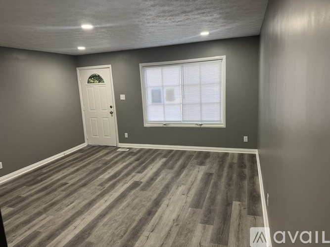 A room with a wooden floor and a white door.