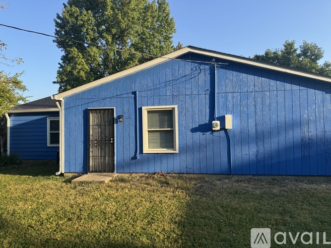 A blue building with a window and a door is available for rent.