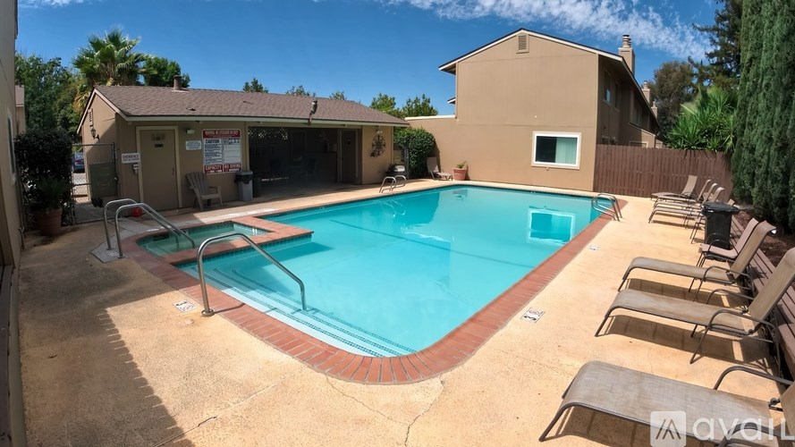 A pool with a red border and a house in the background.