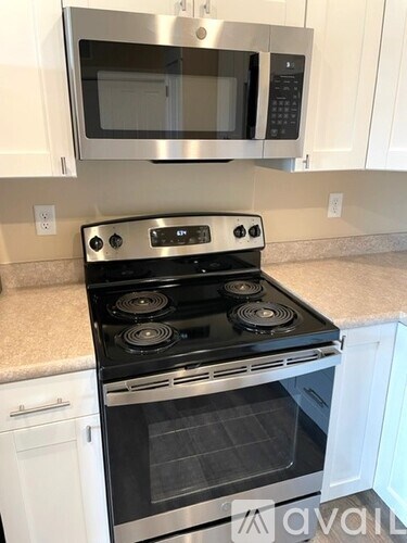 A modern kitchen with a stove top oven and microwave above it.