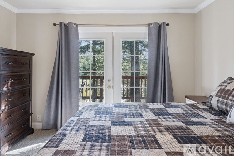 A bedroom with a large bed and a dresser.