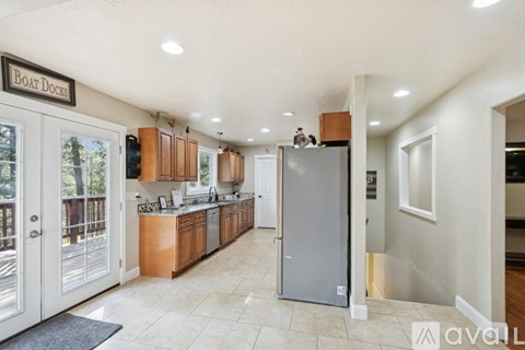 A kitchen with a refrigerator in the middle of the room.