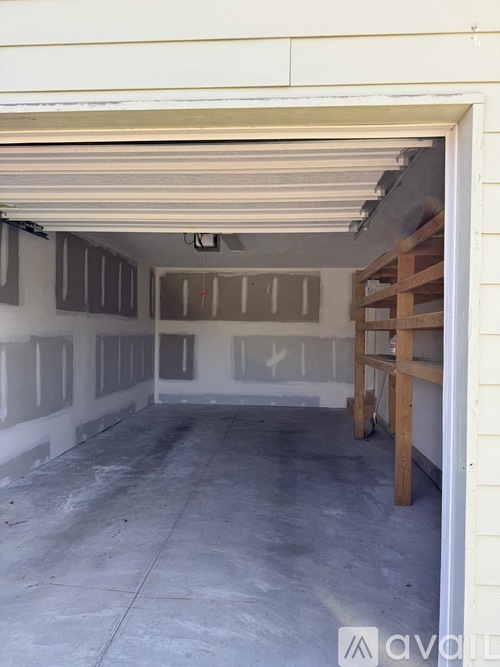 A garage with a white wall and a wooden support beam.