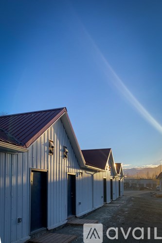 A series of white buildings with dark roofs are lined up in a row.