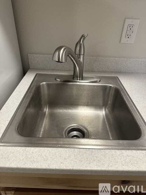 A stainless steel kitchen sink with a single faucet.