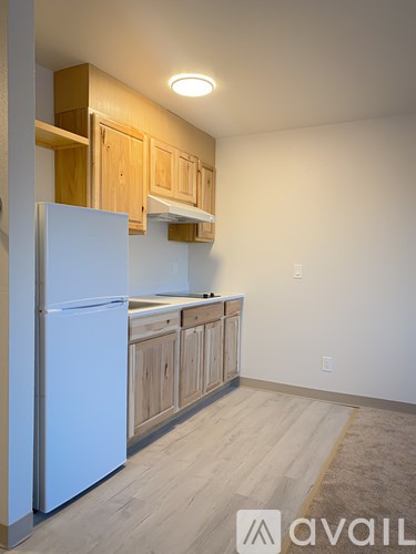 A kitchen with wooden cabinets and a white refrigerator.