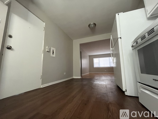 A kitchen with white appliances and wooden floors.