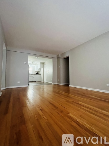 A room with wooden flooring and white walls.