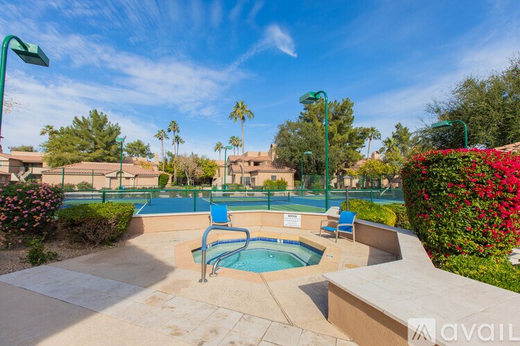 A pool surrounded by a concrete patio and a green lawn.