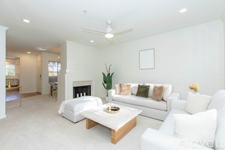 A white living room with a fireplace and a white couch.